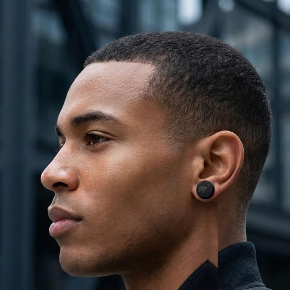 A man seen in profile outdoors, wearing a Keloid Buds disc on his earlobe